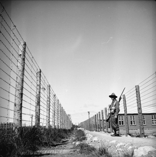 Soldier guarding Japanese prisoner of war camp in Featherston, Wellington. Ref: 1/4-000791-F. Alexander Turnbull Library, Wellington, New Zealand. /records/22802261